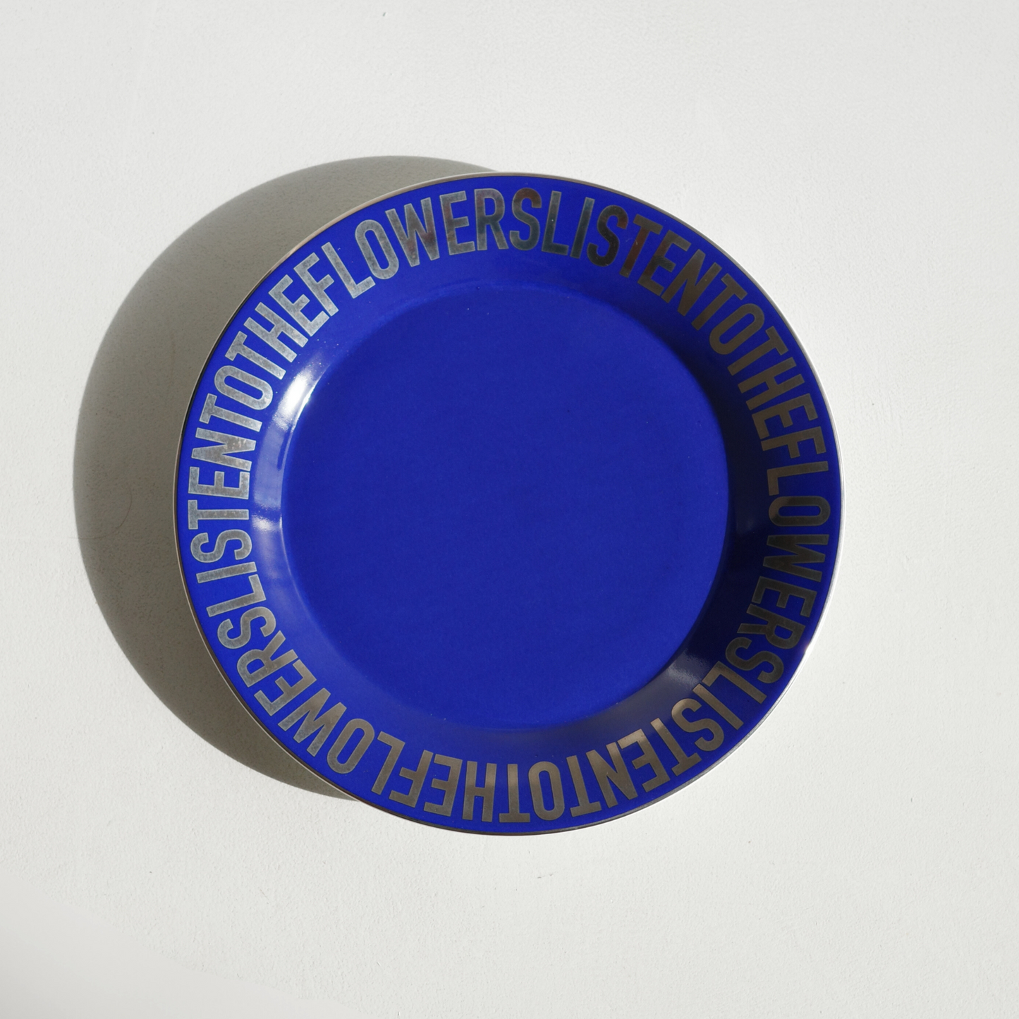 dark blue ceramic plate with chrome lettering